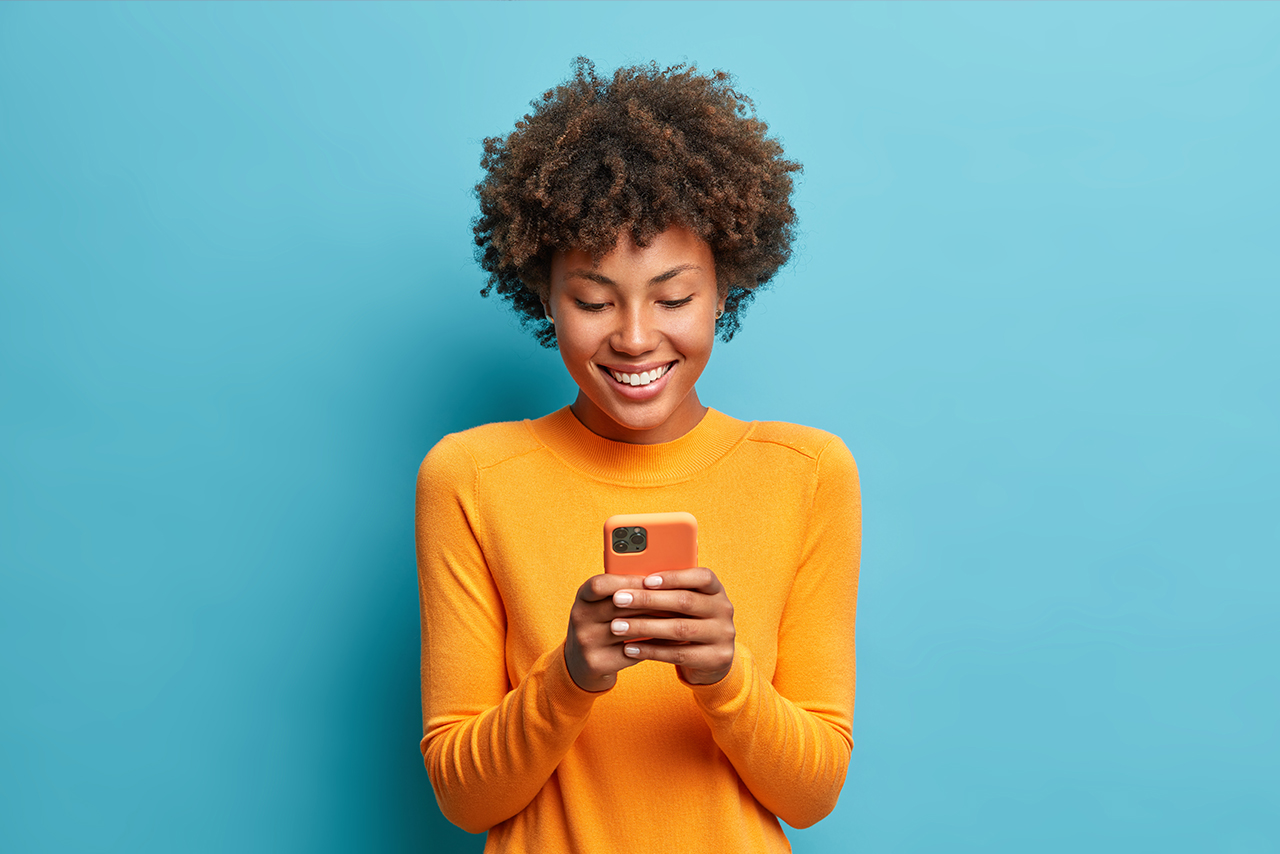 Side view of beautiful woman using her phone indoors. - Mango Media - Creative Studio at Yacht Haven Grande